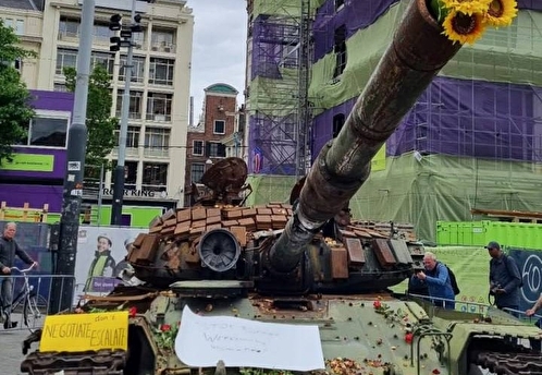 В центре Амстердама люди несут цветы к советскому танку Т-72