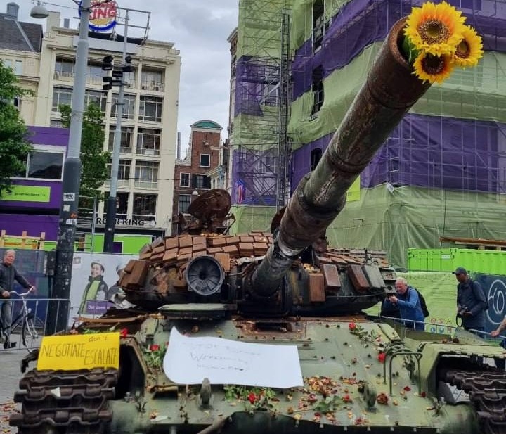 В центре Амстердама люди несут цветы к советскому танку Т-72